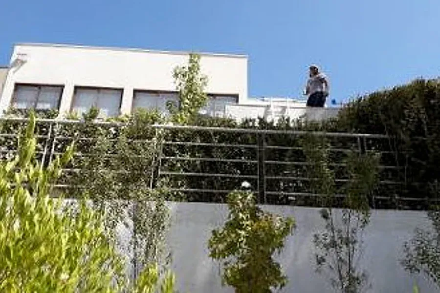 Trabajador en el borde del techo de una casa en Vitacura