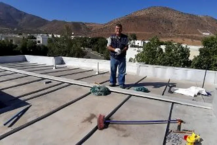 Trabajador sobre un techo de zinc (techo americano) en Chicureo